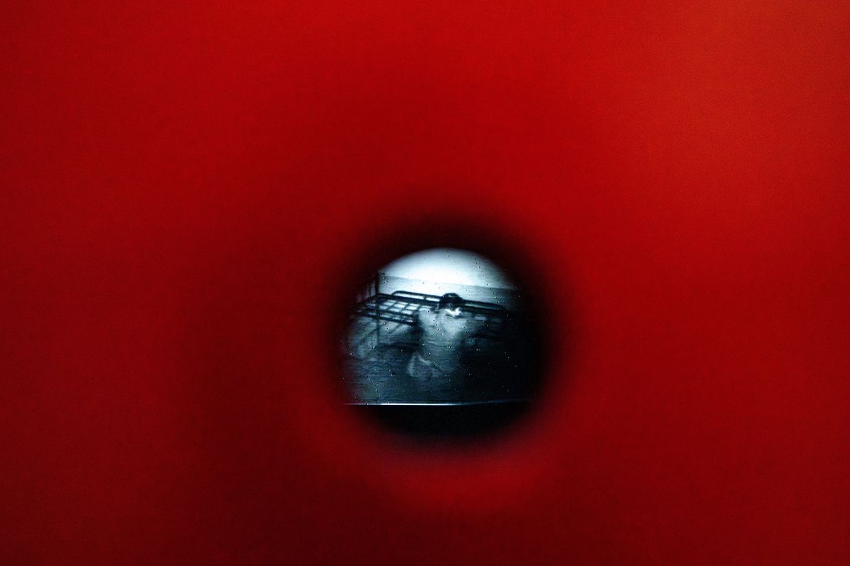 A video from the Communist era secret police surveillance archives, seen through a pinhole, at the 'A.REST 1989' exhibition. Photo: AP