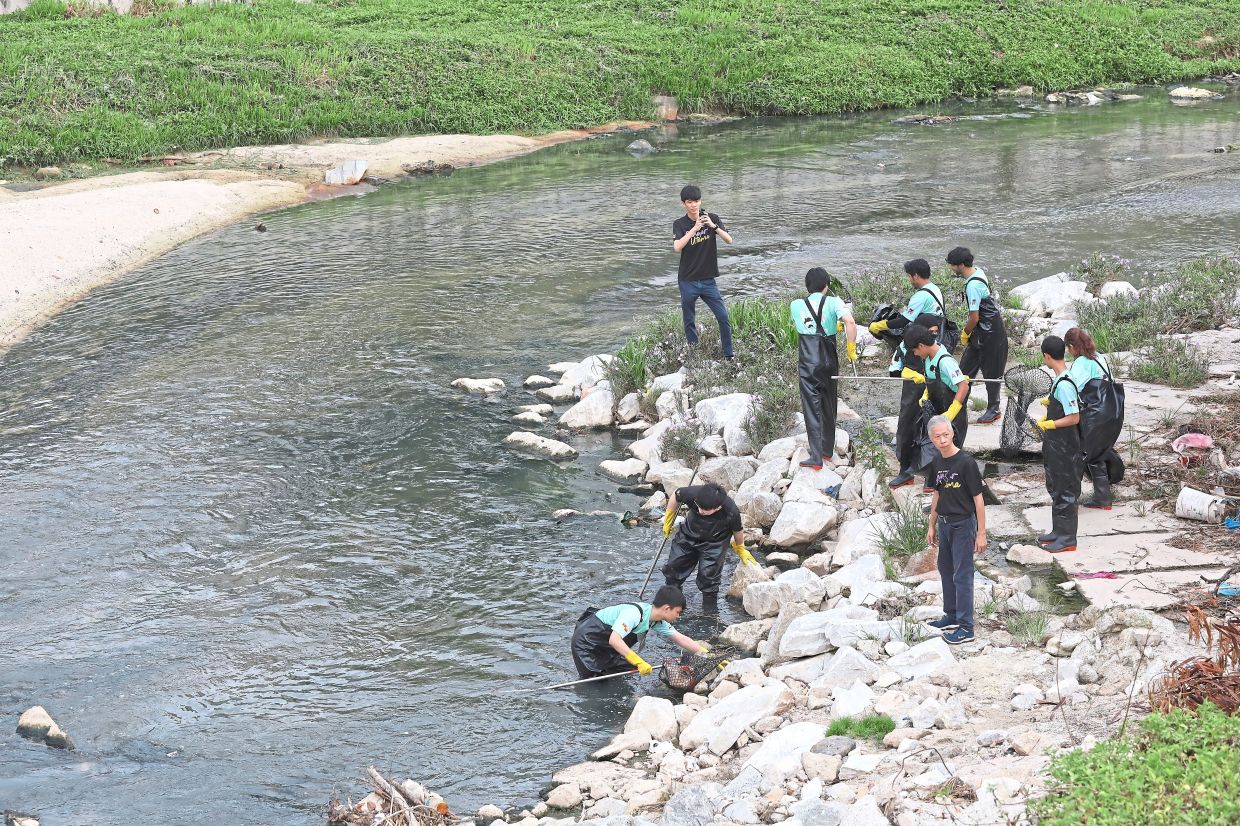Volunteers cleaning up Kampung Chempaka Retention Pond in Petaling Jaya, amassing over half a tonne of rubbish.