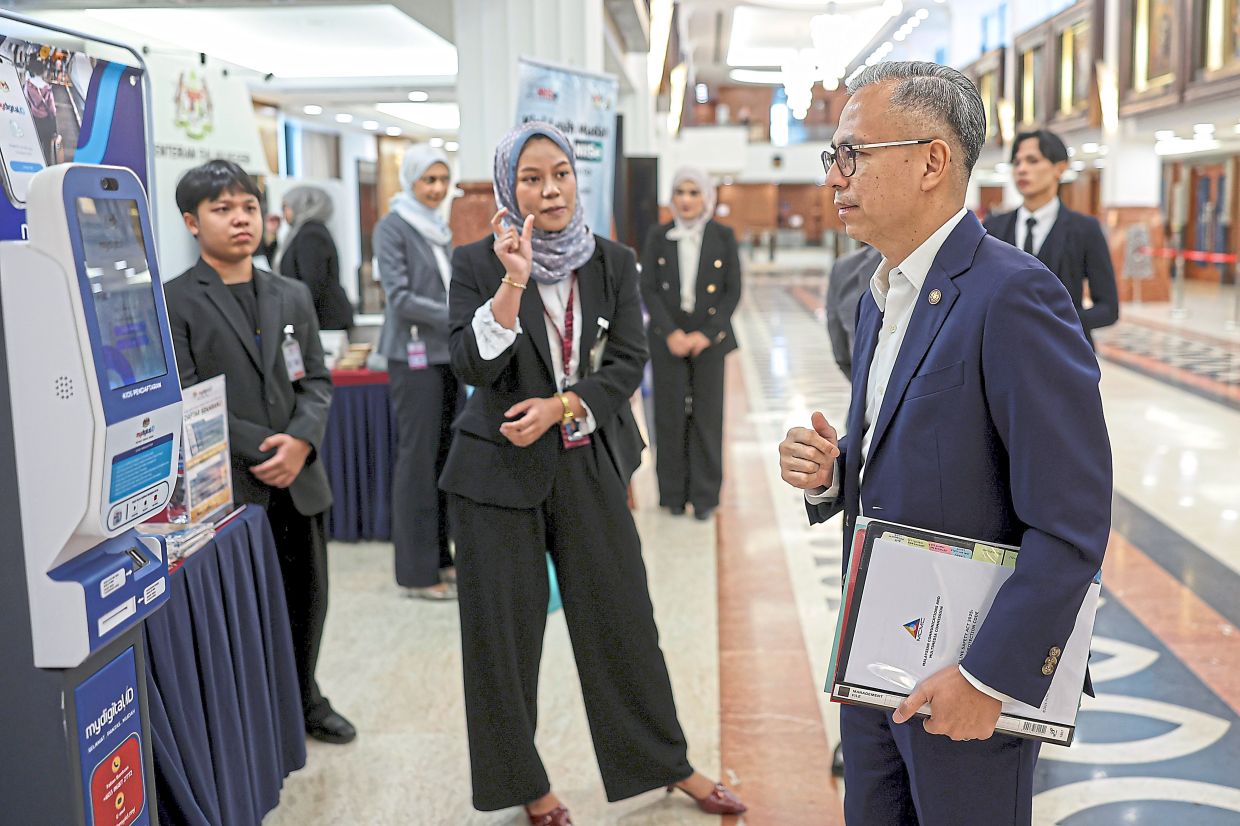 Tech briefing: Fahmi speaking with MyDigital ID staff members at the Parliament lobby in Kuala Lumpur. — Bernama