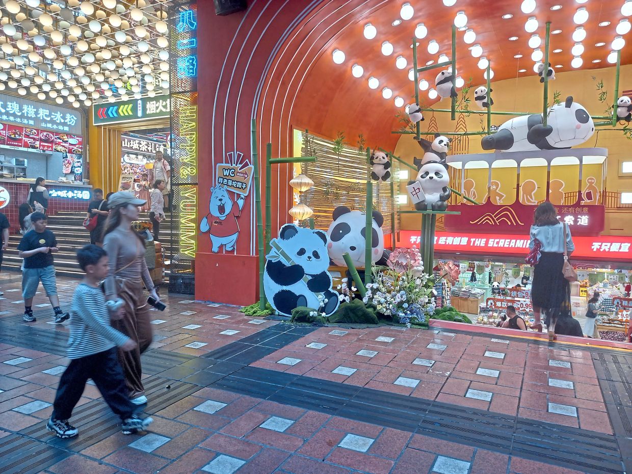 Pandas everywhere! Descend the steps to get into this souvenir shop in Chongqing. But to check out the restaurant next door, you would have to climb up the stairs. -- FOO YEE PING/The Star