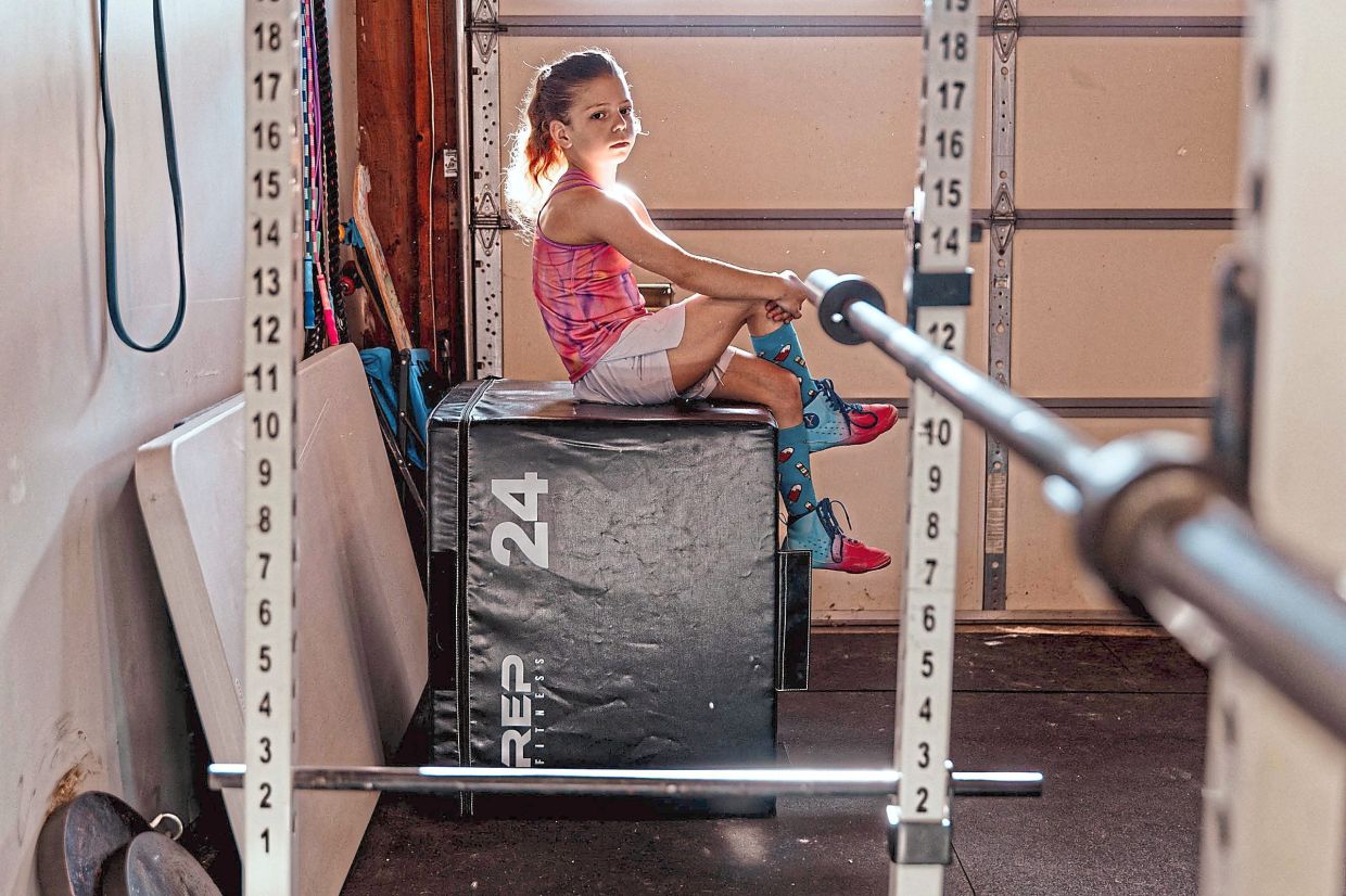 Lucy at her home gym in Long Island, New York. For kid fitness influencers, pumping iron can feel like play. Photo: The New York Times