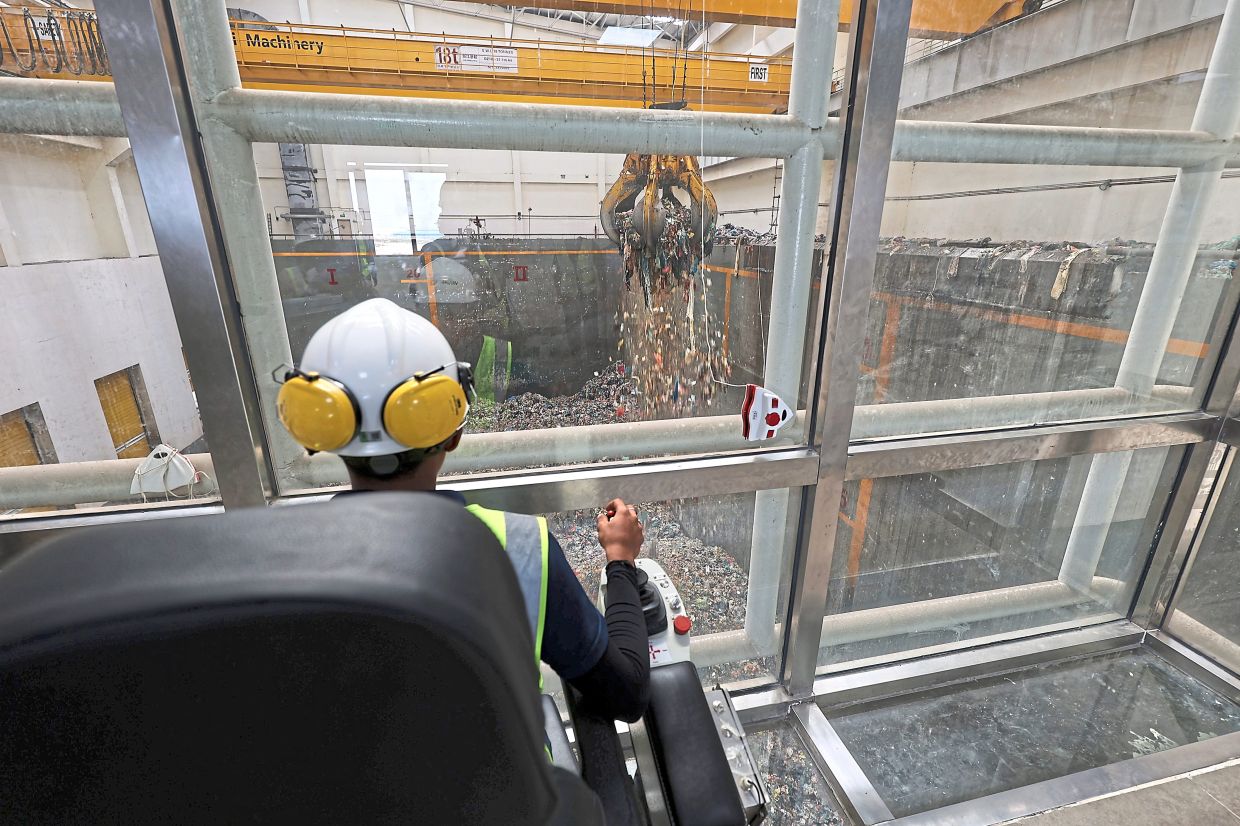 An operator manoeuvring the giant steel claw at WtE 1.