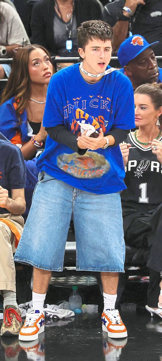 Timothee Chalamet leans into the oversized shorts trend, opting for an elongated denim silhouette courtside. Photo: Getty Images via AFP
