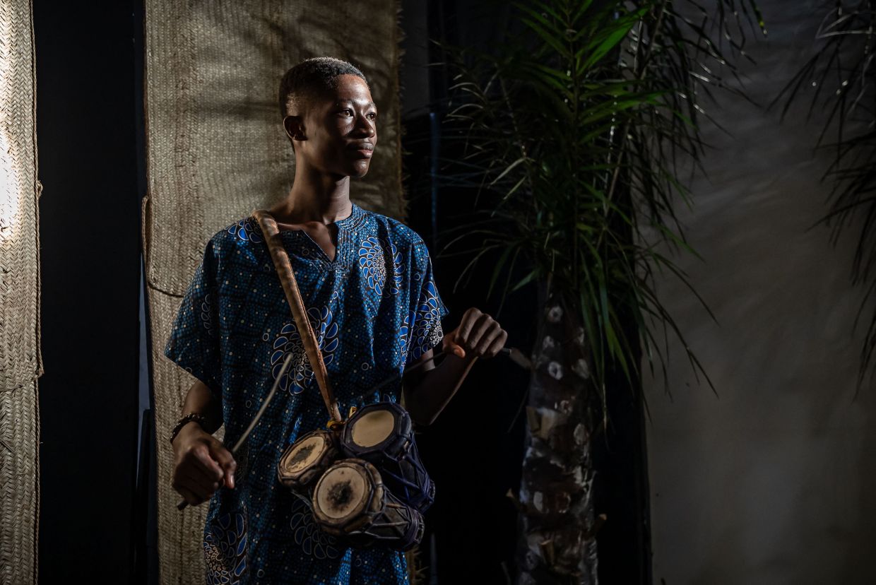 A traditional drummer poses for a photograph as he performs on stage ahead of a performance of 'Medaaye', a play by Nigerian writer Femi Osofisan. Photo: AFP 