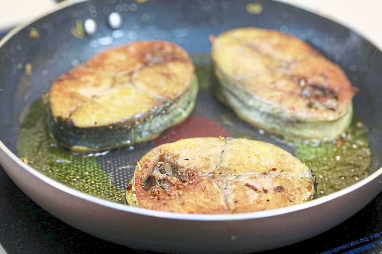 In the seasoned oil, fry the fish until golden brown.