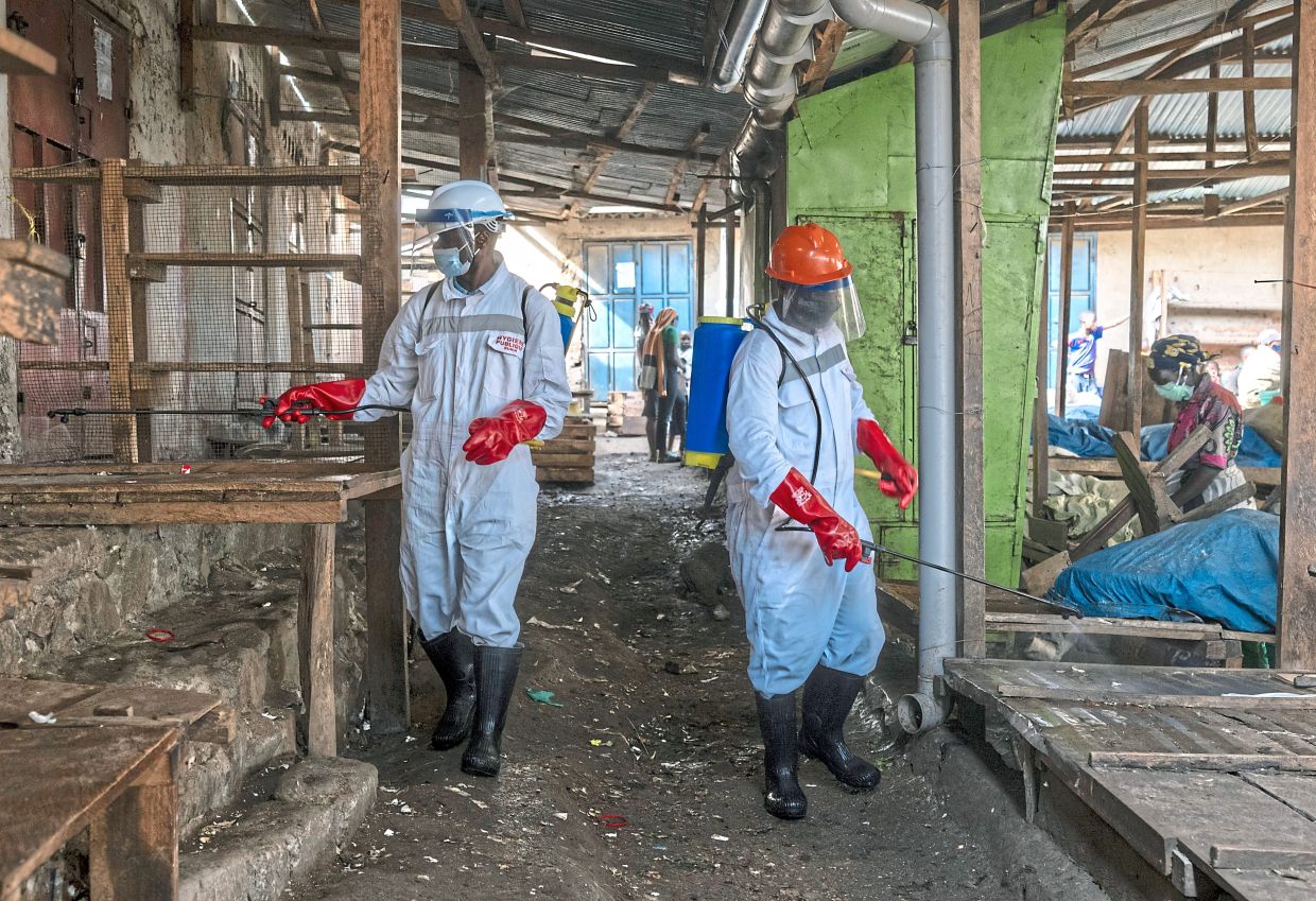 Health workers disinfect a public market in Bunia, as part of the response to the Ebola outbreak in the Democratic Republic of Congo. Running so far behind the virus, intervention has become less about vanquishing Ebola than about simply trying to slow its steamroller advance across the region. — Arlette Bashizi/The New York Times