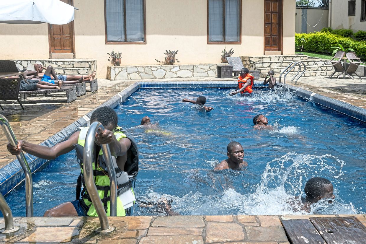 Young people swimming in a hotel pool in Bunia, the heart of the Ebola outbreak in the Democratic Republic of the Congo. For Bunia, a lush city on the edge of a sprawling rainforest, the outbreak is the latest of many calamities. — Arlette Bashizi/The New York Times