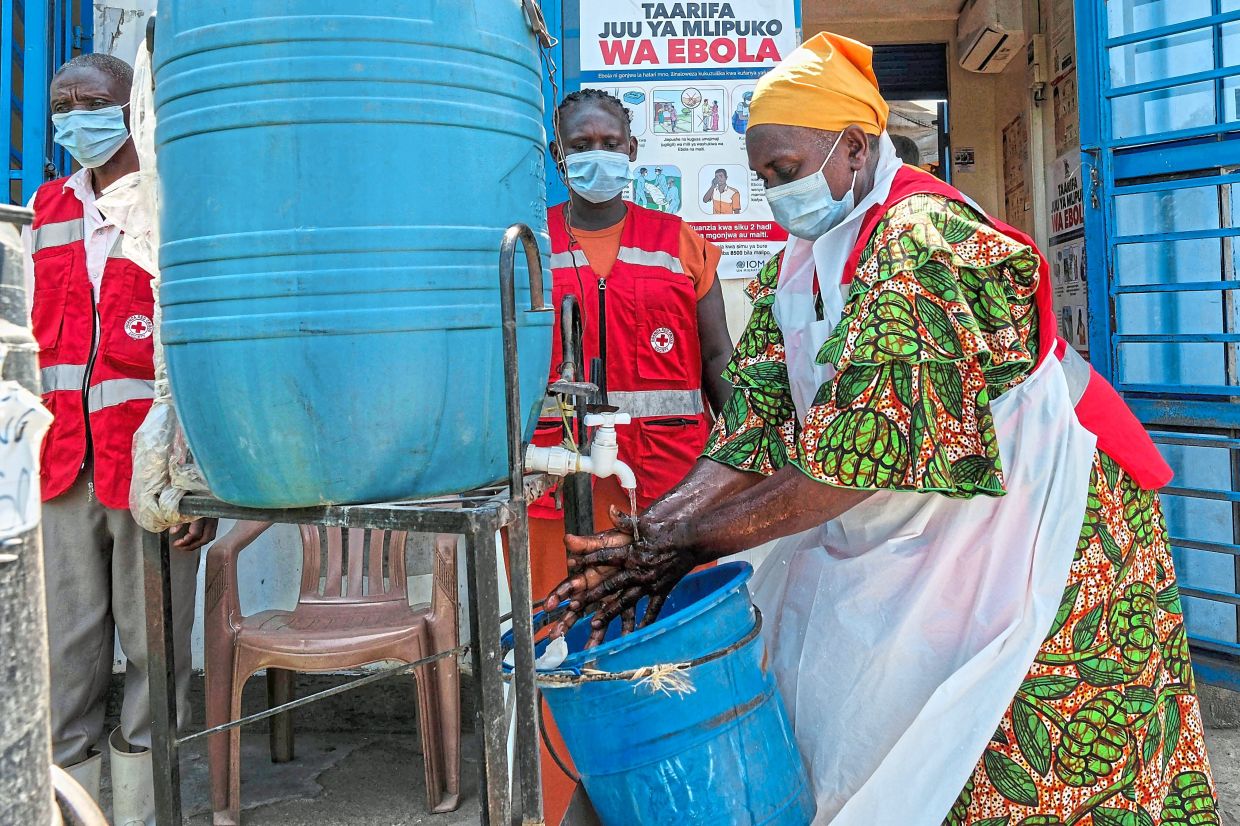 A health worker washing her hands at a temporary health clinic at the Mpondwe border crossing linking Uganda and the Democratic Republic of the Congo. Although the outbreak is concentrated in Ituri, it has also been detected in two other provinces as well as in neighbouring Uganda. — AP