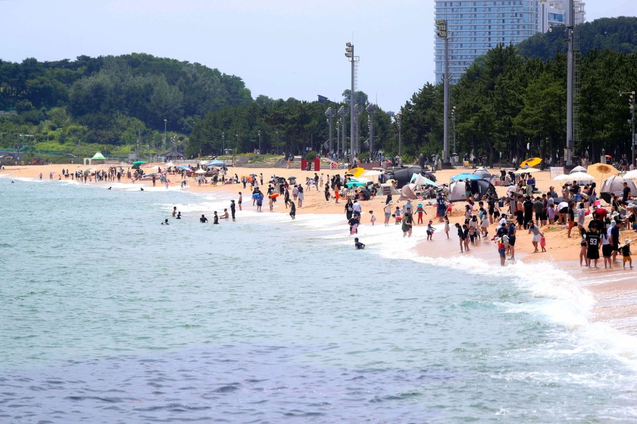 Vacationers crowd Sokcho Beach in Gangwon Province on Saturday to escape the heat. The beach is set to open July 3. - Photo: Yonhap