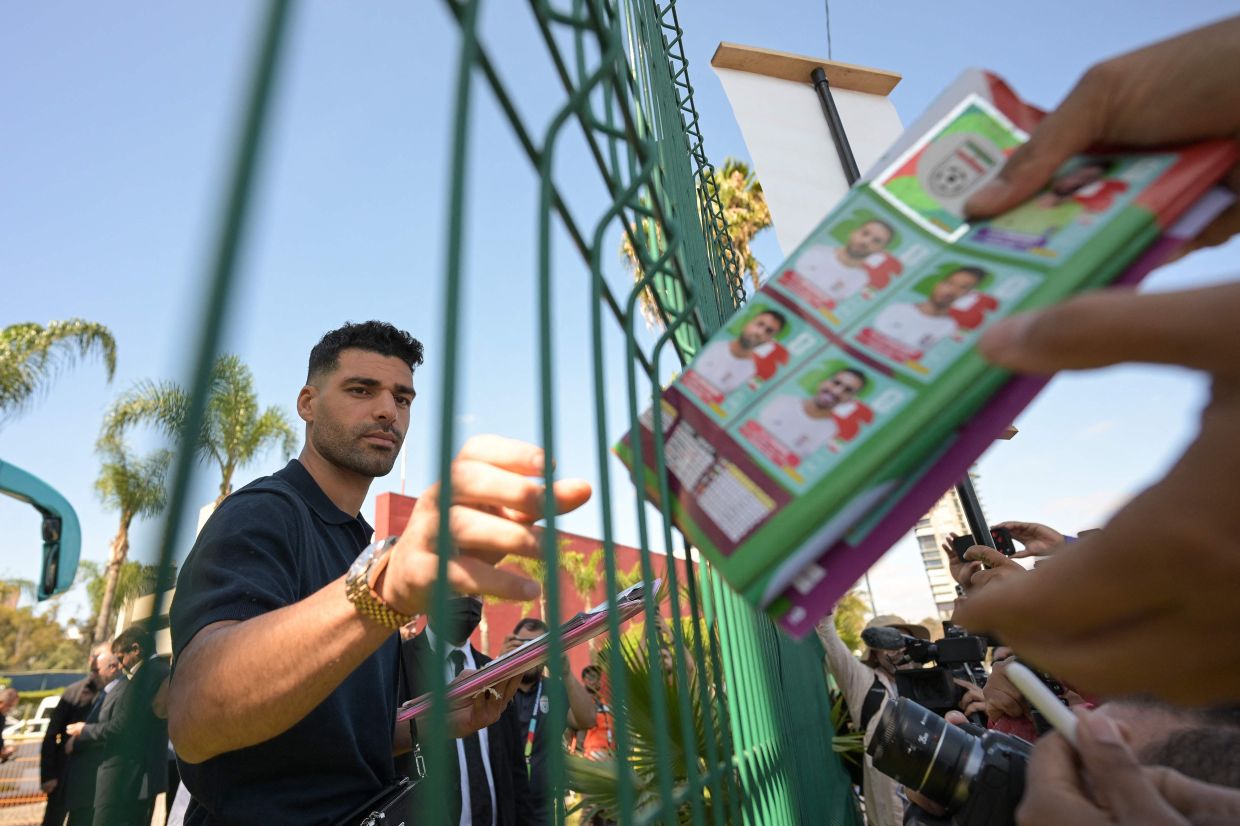 Iran forward Mehdi Taremi signs a Panini album at the Marriott Hotel in Tijuana, Mexico on June 20. Photo: AFP