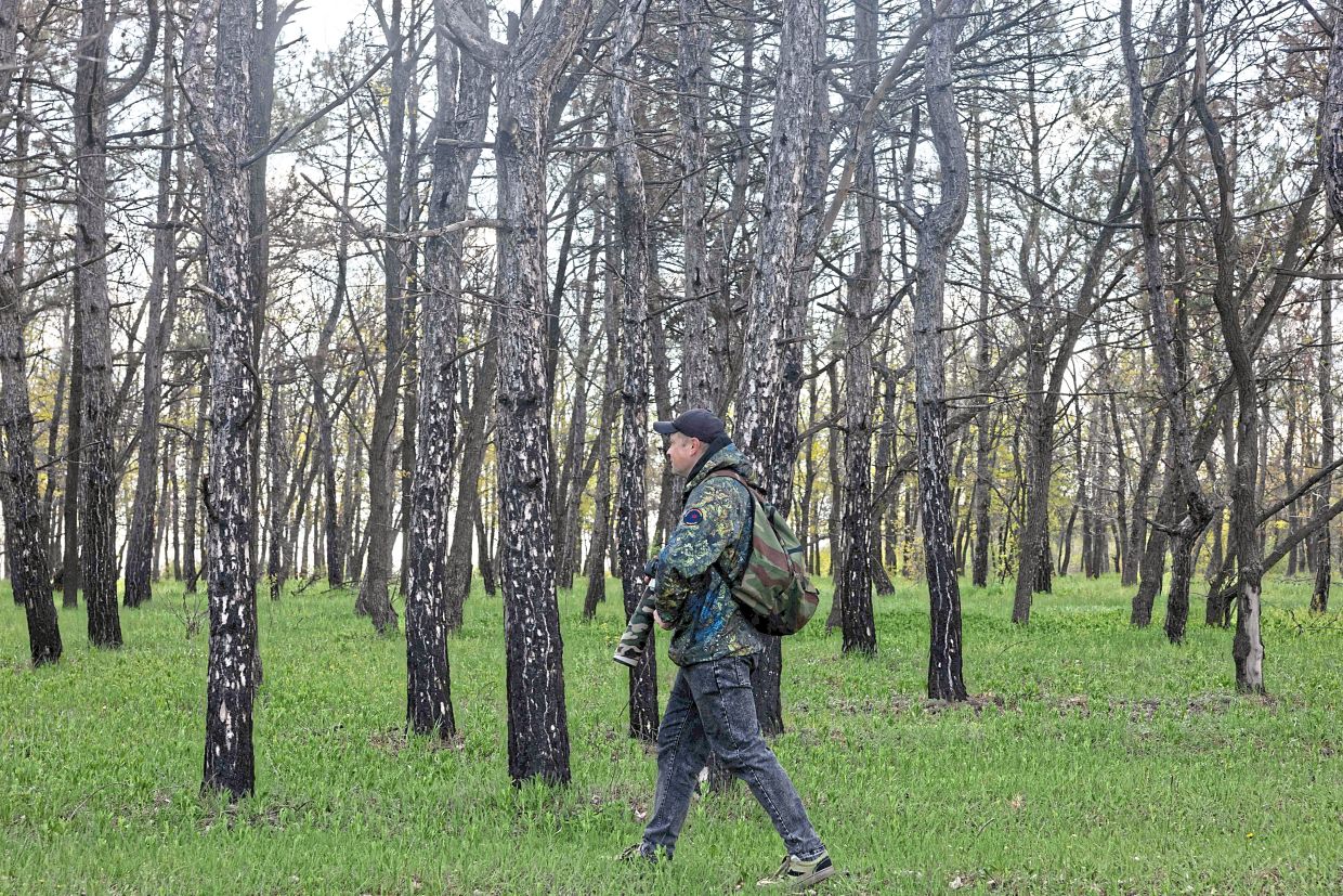 Sevidov walks around with a camera during a bird photography shoot in Kryvyi Rig.