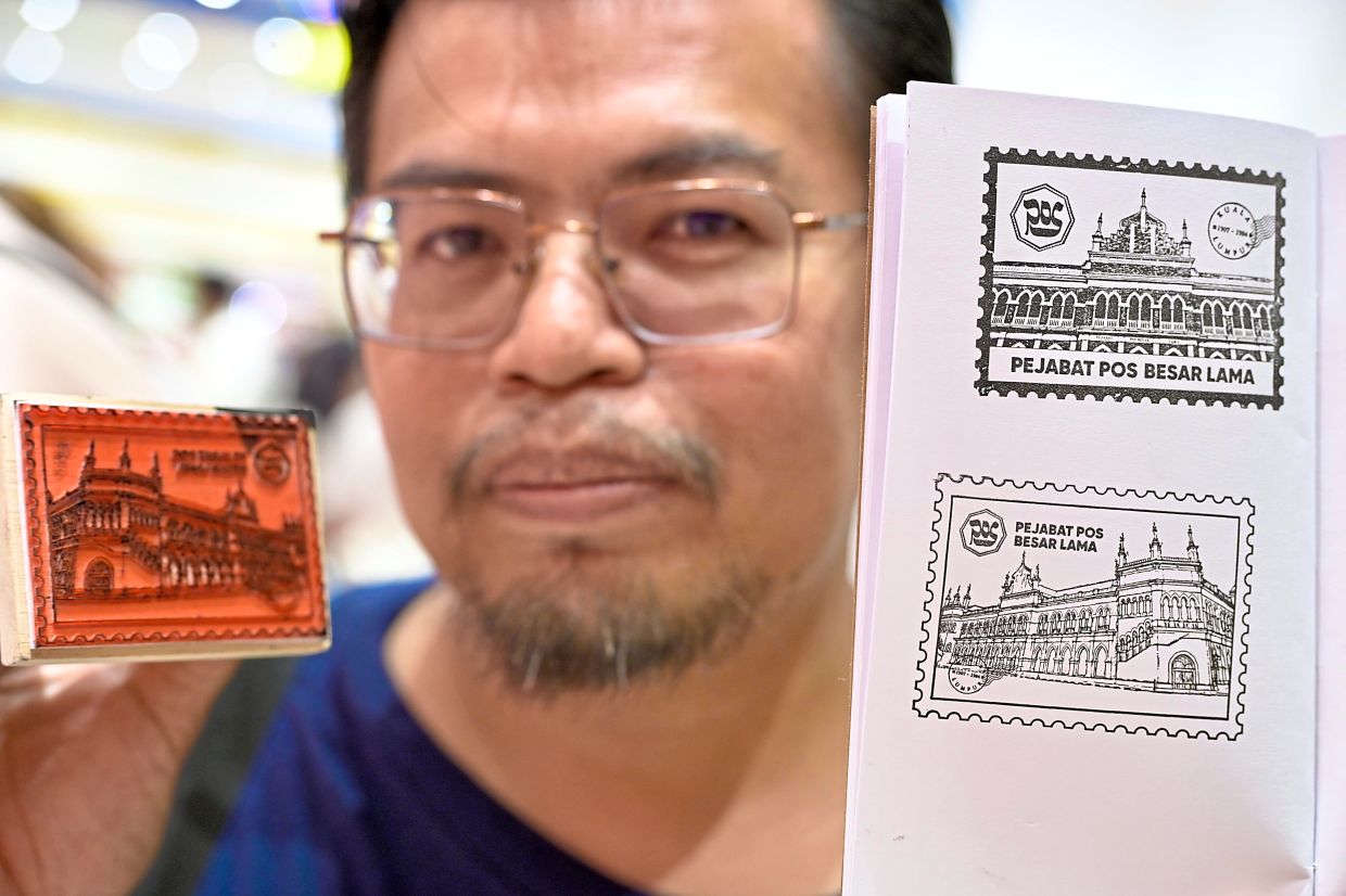 Herman Kastro showing his ink stamp booklet with commemorative designs.
