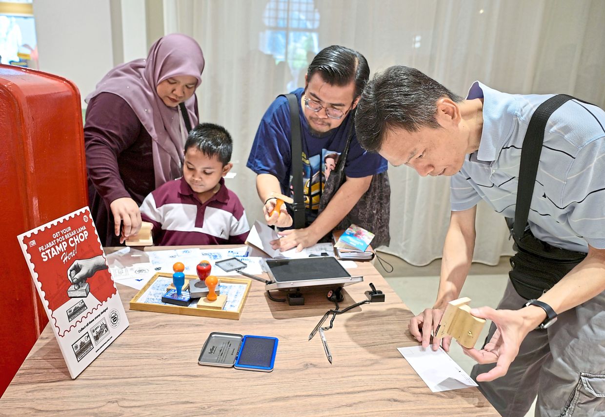 Above: Visitors trying their hand at the stamping activity.