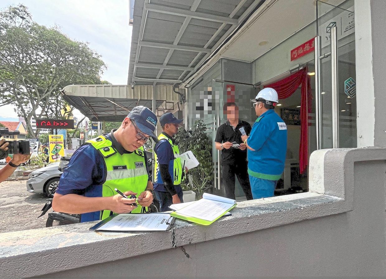 SPAN and IWK officers at a commercial premises during Ops Mutiara at Kelawei Road in George Town.
