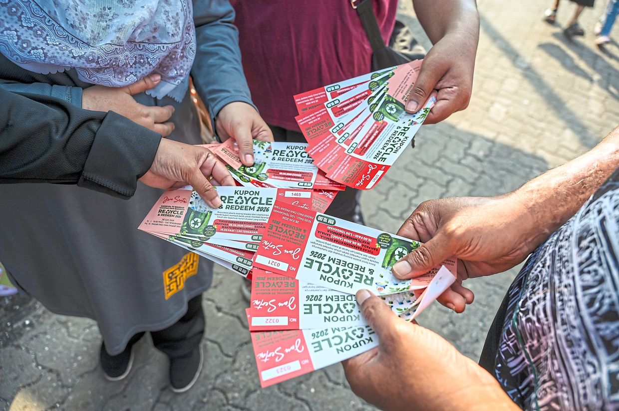 Residents showing the coupons earned through the recycling drive.