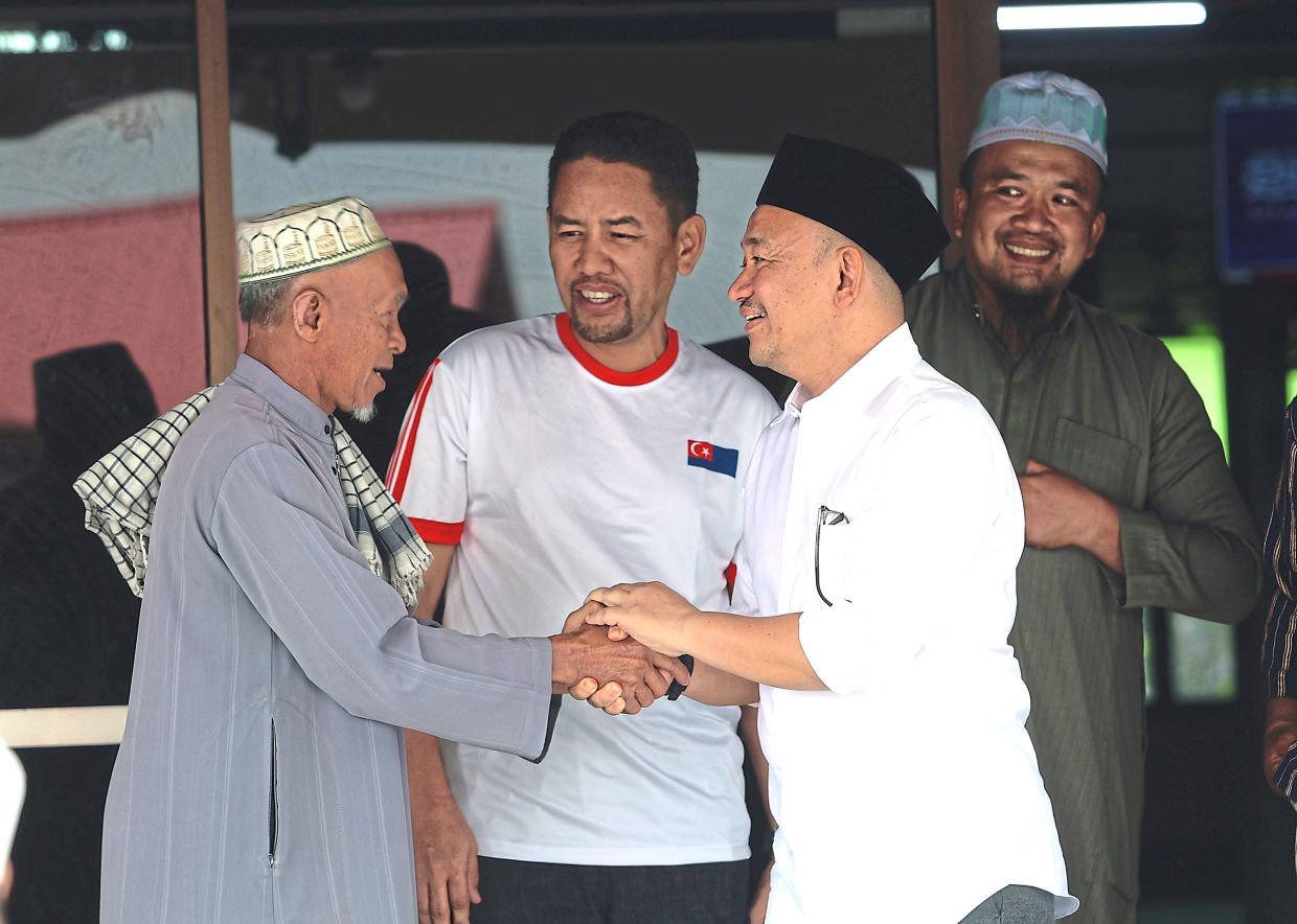 Pakatan Harapan Puteri Wangsa candidate Dr Maszlee Malik (right) shaking hands with a local during his campaign stop at a mosque in Felda Tebrau here in Johor Baru on Monday. (June 29) — CHAN TAK KONG/The Star