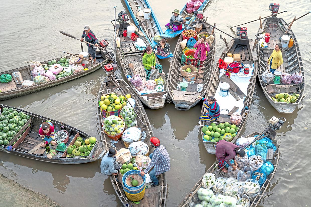 You’ll see boats loaded with fruits and other goods at Cai Rang market in Vietnam.