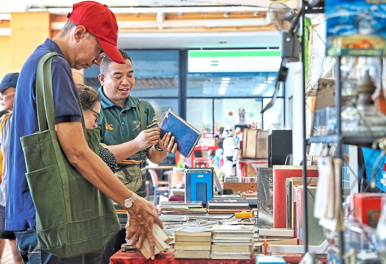 Zharif (right) of HUBooks believes in letting customers browse freely, noting that a rare book often has its own reader waiting for it. Photo: The Star/Muhamad Shahril Rosli