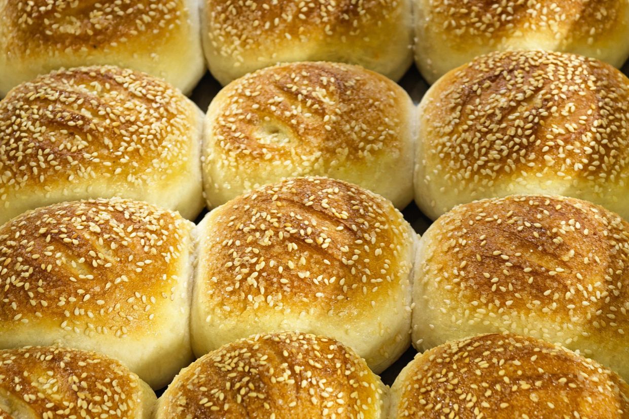 Bread loaves baking in a traditional wood-fired oven at Hiap Joo Bakery.