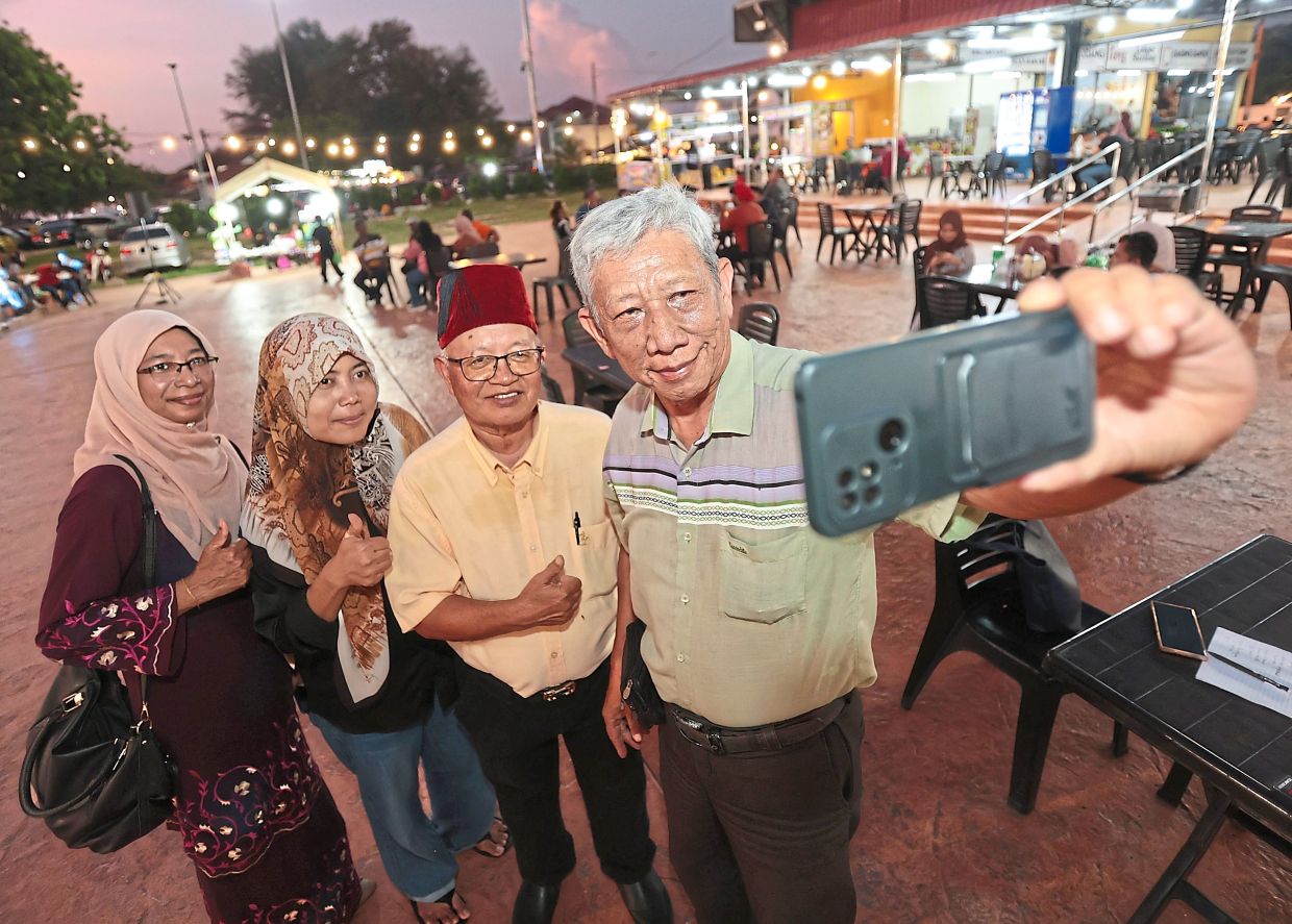 (From right) Muzmi taking a wefie with Omar, Adik Putra’s mother Deny Syafitri Harap and his wife Siti Nur at the music festival at Robina Eco Park in Teluk Air Tawar.