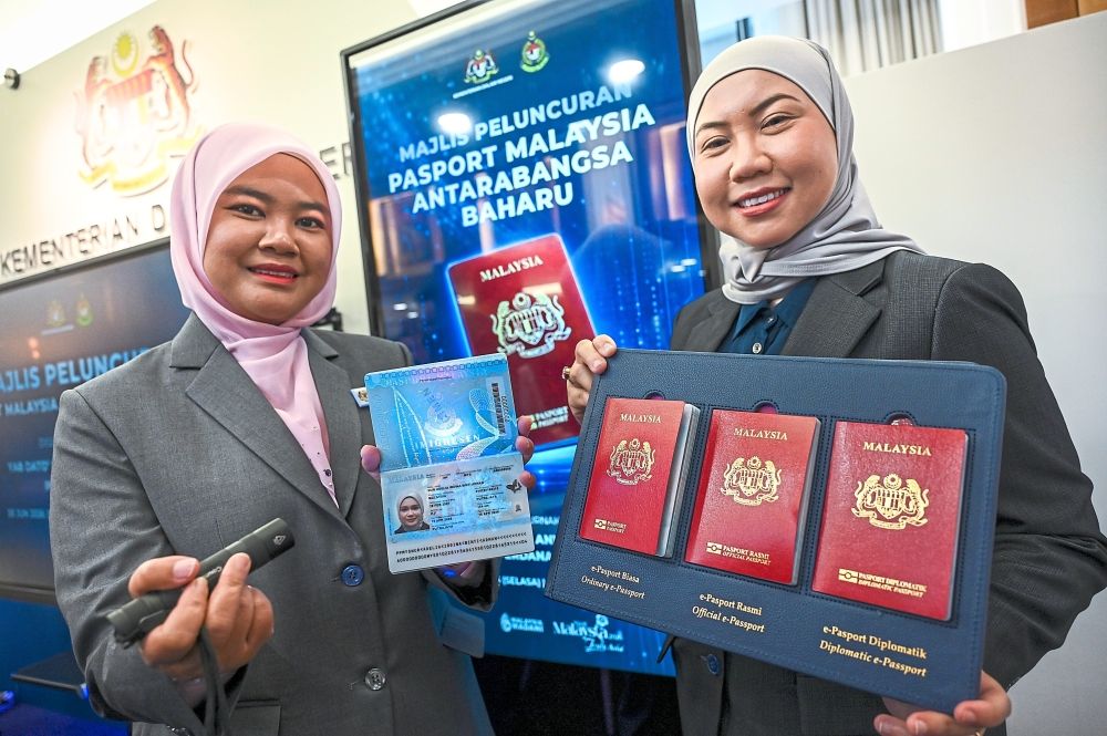 Stamp of approval: Putrajaya Immigration Department staff members presenting the holographic element and other enhanced safety features of the new passport during its official launch atParliament in Kuala Lumpur. - Photo: IZZRAFIQ ALIAS/The Star