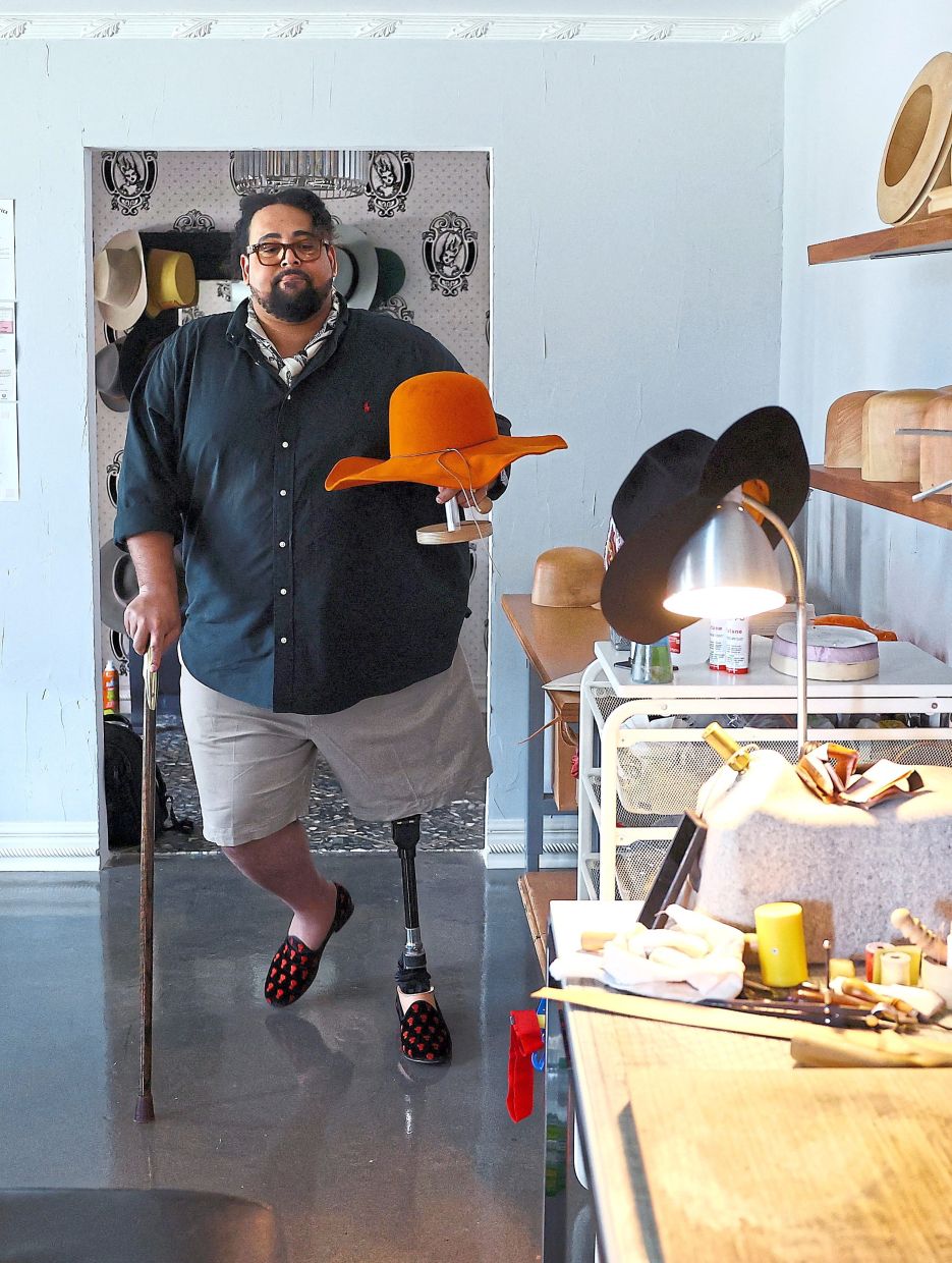 Fields holding a hat he made for a Dutch football fan at his studio in Dallas.