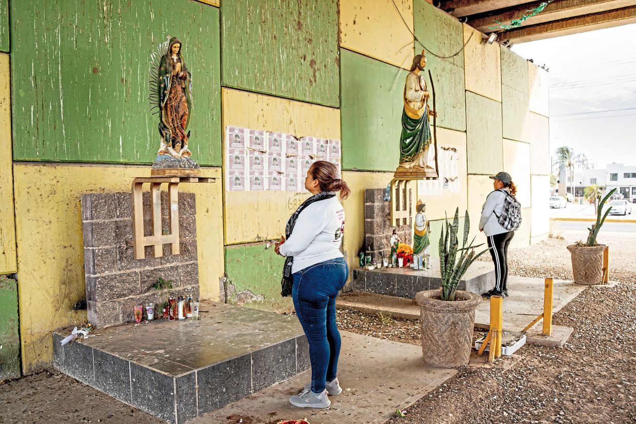 Flores (foreground) praying beneath a highway overpass in Juan Jose Rios. As one of the most prominent activists for Mexico’s disappeared, she recently found the remains of one missing son. Now she has turned her attention to finding the other. — Fred Ramos/The New York Times