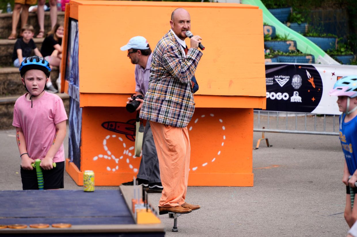 Will Weiner, producer and CEO of XPogo (centre), pogos as he mc's a pogo event for neighborhood youngsters following the conclusion of competition at Pogopalooza 2026.