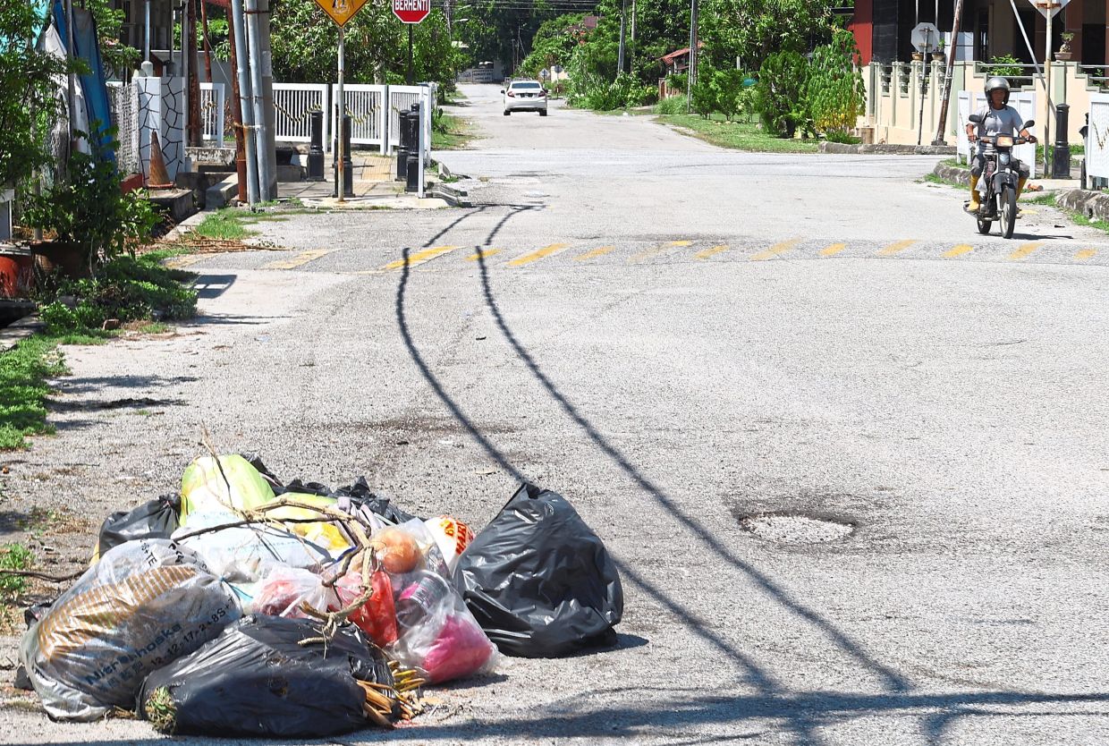 Illegal dumping and potholes at Jalan Gunung Rapat.