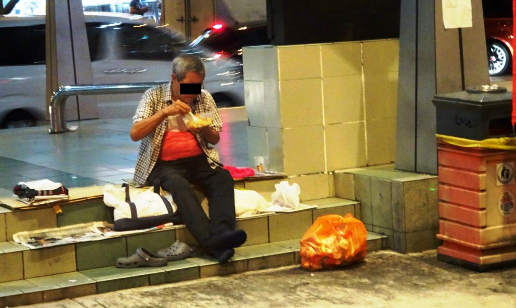 The hungry are grateful for the free meals given by good Samaritans and organisations which they often eat, sitting on the pavements. — LILY FU