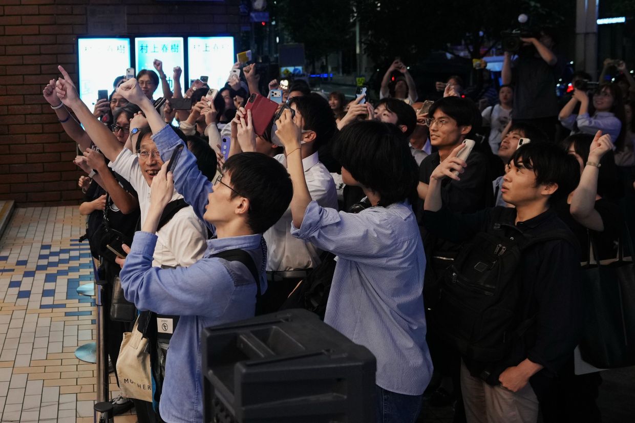 People count down during an event to receive copies they pre-purchased, of Haruki Murakami's new book.