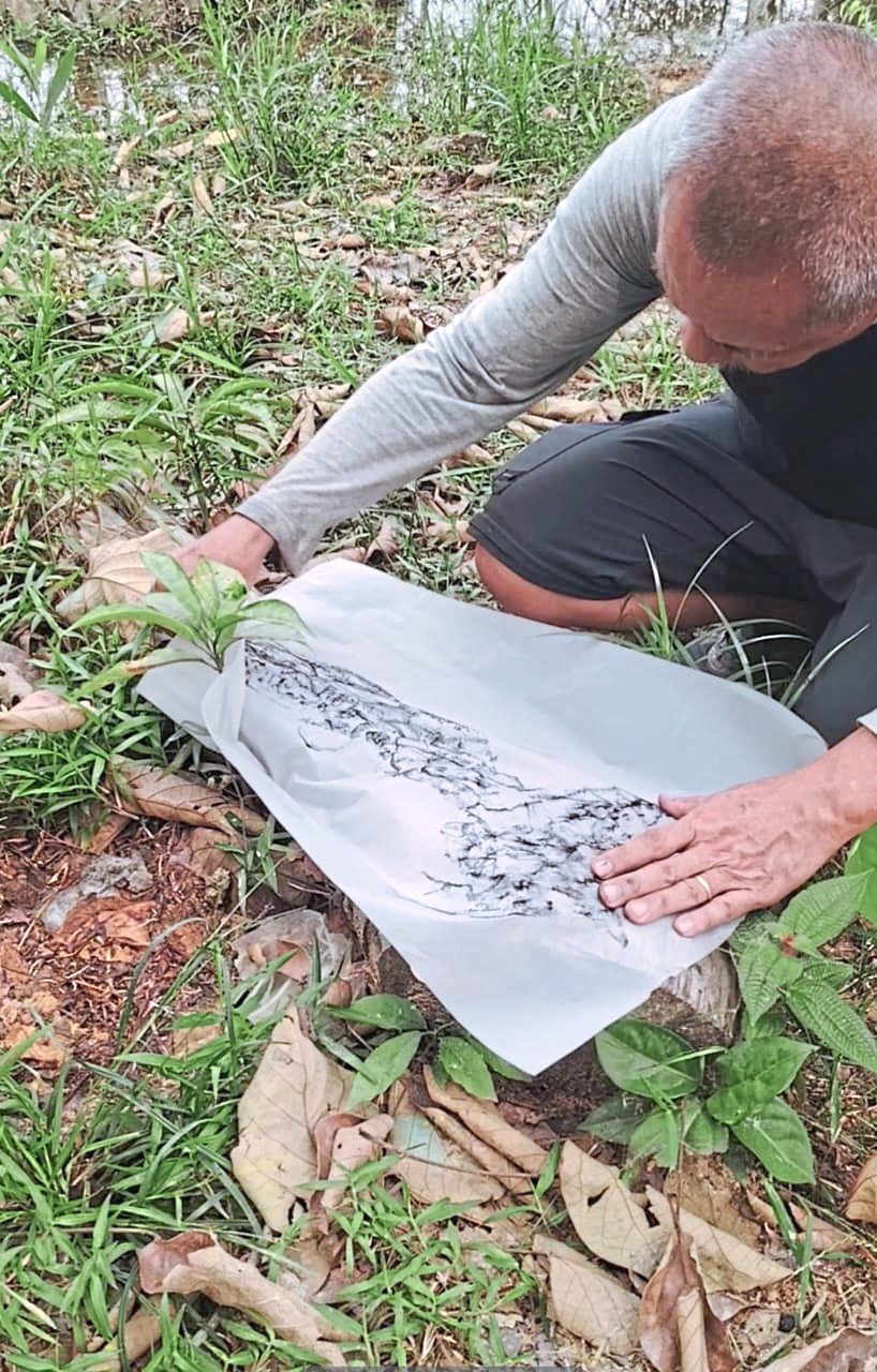 Lok creates a forest-floor tracing at Sungai Buaya, one of nearly 100 forest-derived works shown in the 'Forest Speaks' exhibition. Photo: Green Tree Plantation