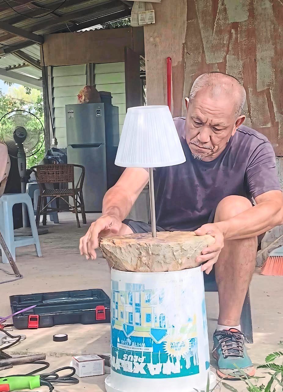 Lok assembles a lamp for Forest Speaks using materials sourced directly from the Sungai Buaya forest. Photo: Green Tree Plantation