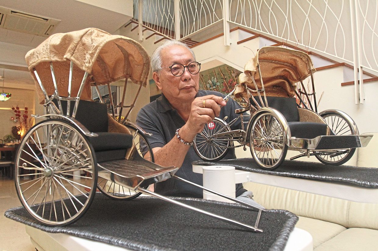 Lee putting the finishing touches to his handmade stainless steel miniature trishaw and rickshaw at his home.