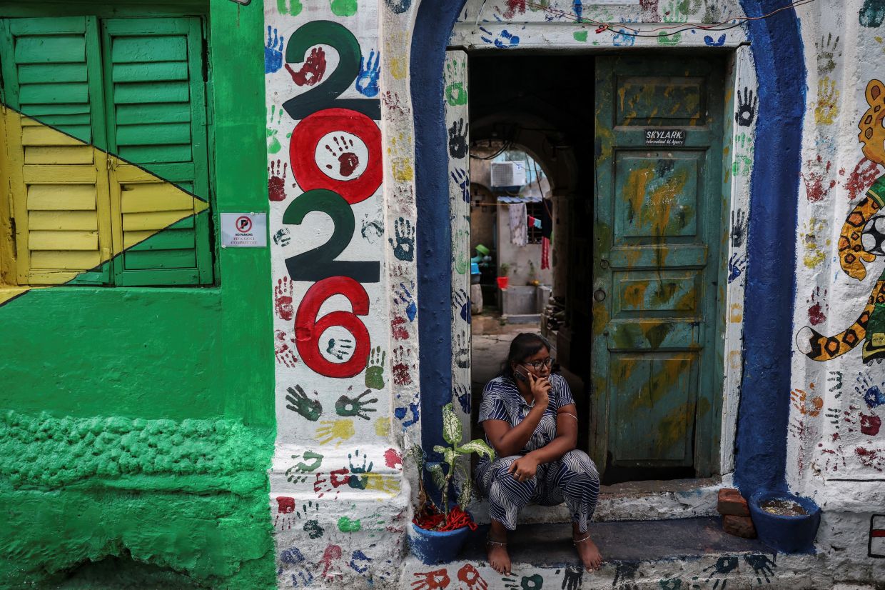 A woman speaks on the phone outside her residence on FIFA Gully, a street decorated in celebration of the 2026 FIFA World Cup, in Kolkata, India. Photo: Reuters 