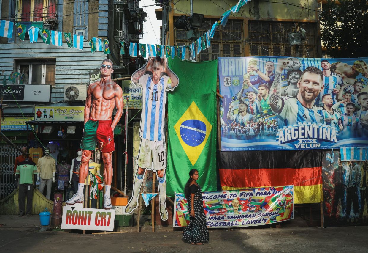 A woman walks past street decorations in Kolkata, India, put up to celebrate the ongoing 2026 FIFA World Cup tournament. Photo: Reuters