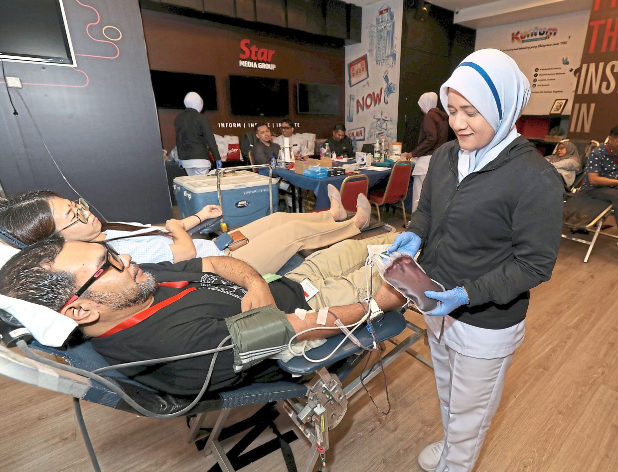 Adznam being tended to by a National Blood Centre nurse while donating blood for the 13th time.