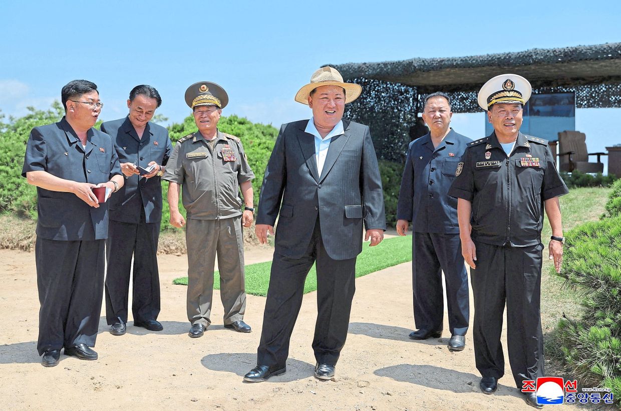 Sea power: Kim and other officials reacting to an assessment of the Kang Kon’s (top) weapons systems, including the test firing of a cruise missile, from an unknown location in North Korea. — Korean Central News Agency via AFP/Reuters