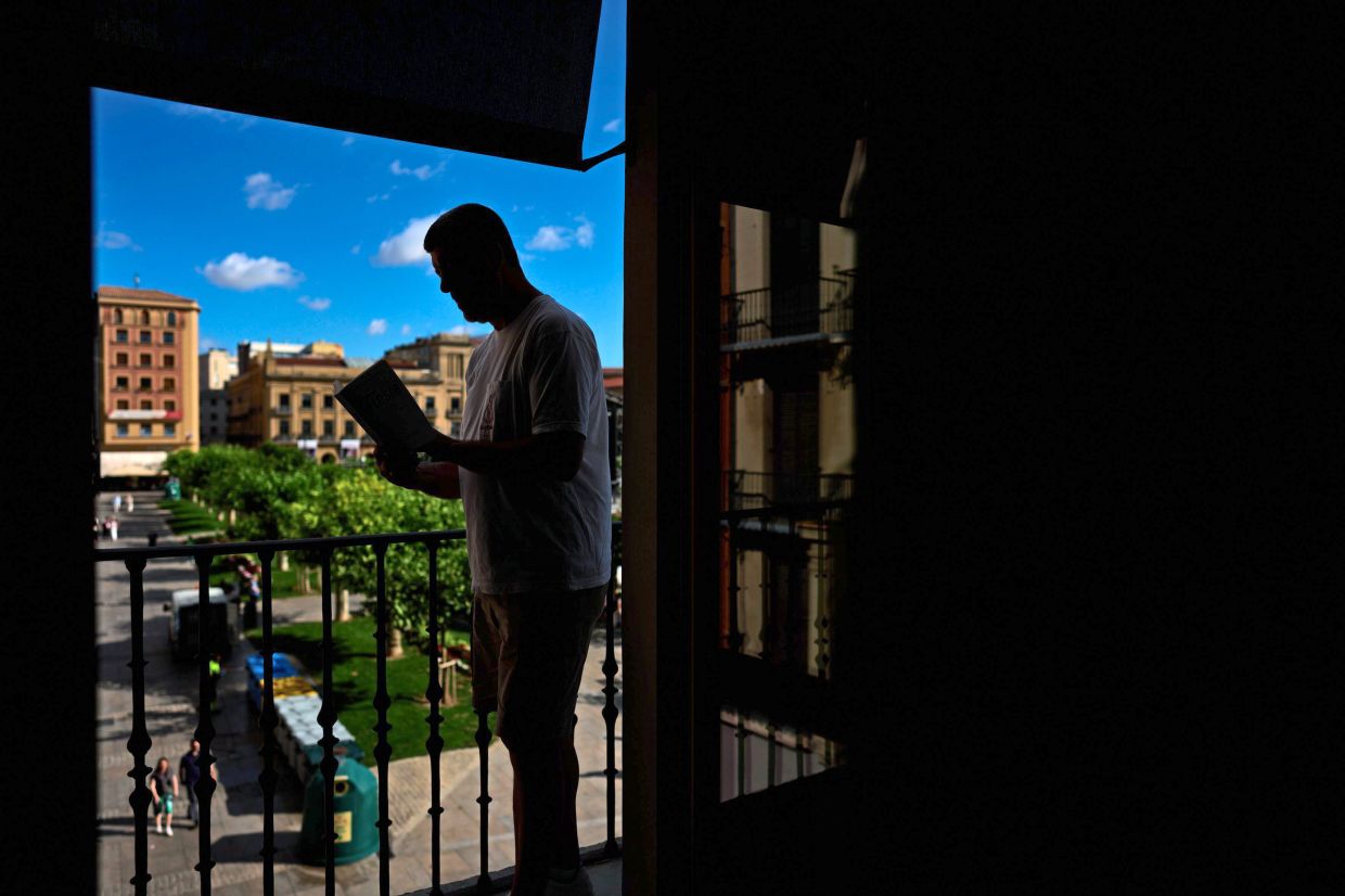 A tourist reads Hemingway's novel 'Fiesta' in the Ernest Hemingway Suite at the Gran Hotel La Perla in Pamplona, northern Spain. Photo: AP 
