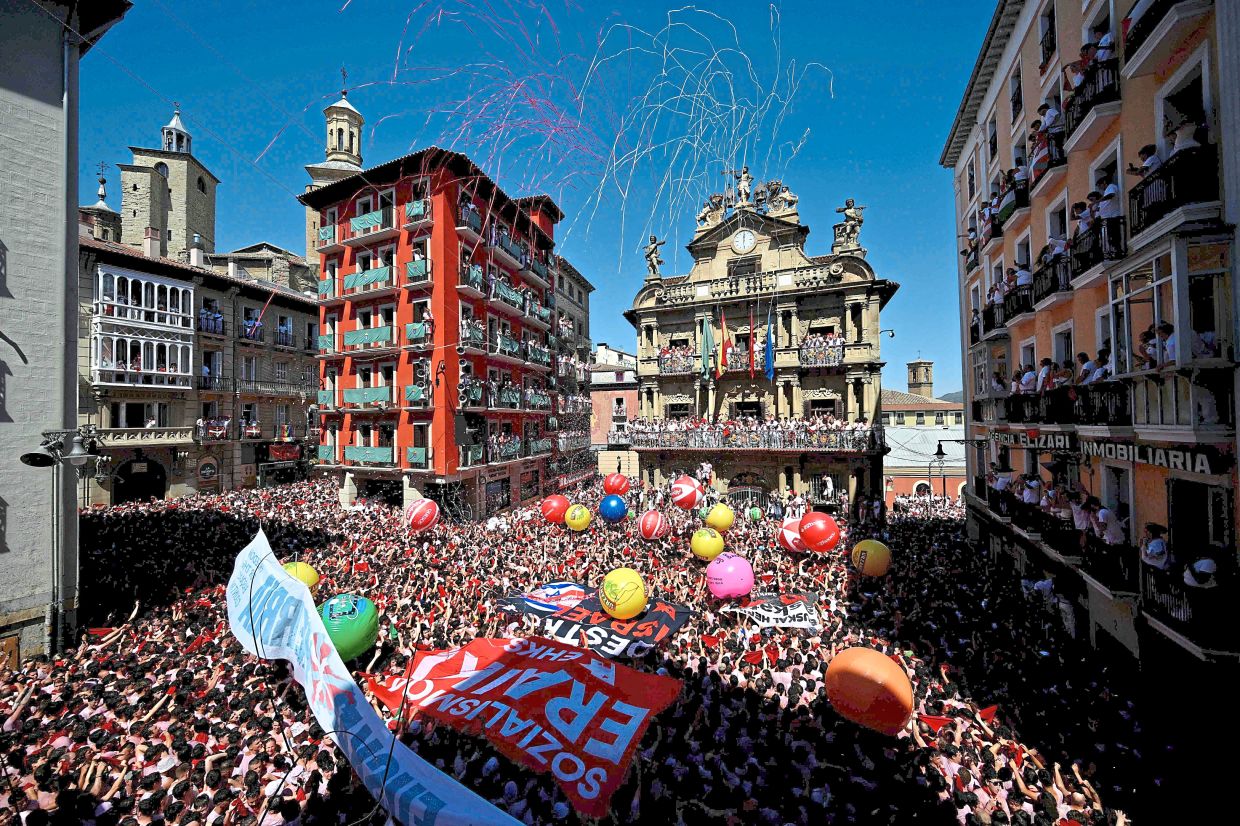 Revellers wave their red scarves during the 'Chupinazo' (rocket launch) marking the official start of the San Fermin Festival in Plaza Consistorial outside the Town Hall of Pamplona in northern Spain on July 6. Photo: AFP 
