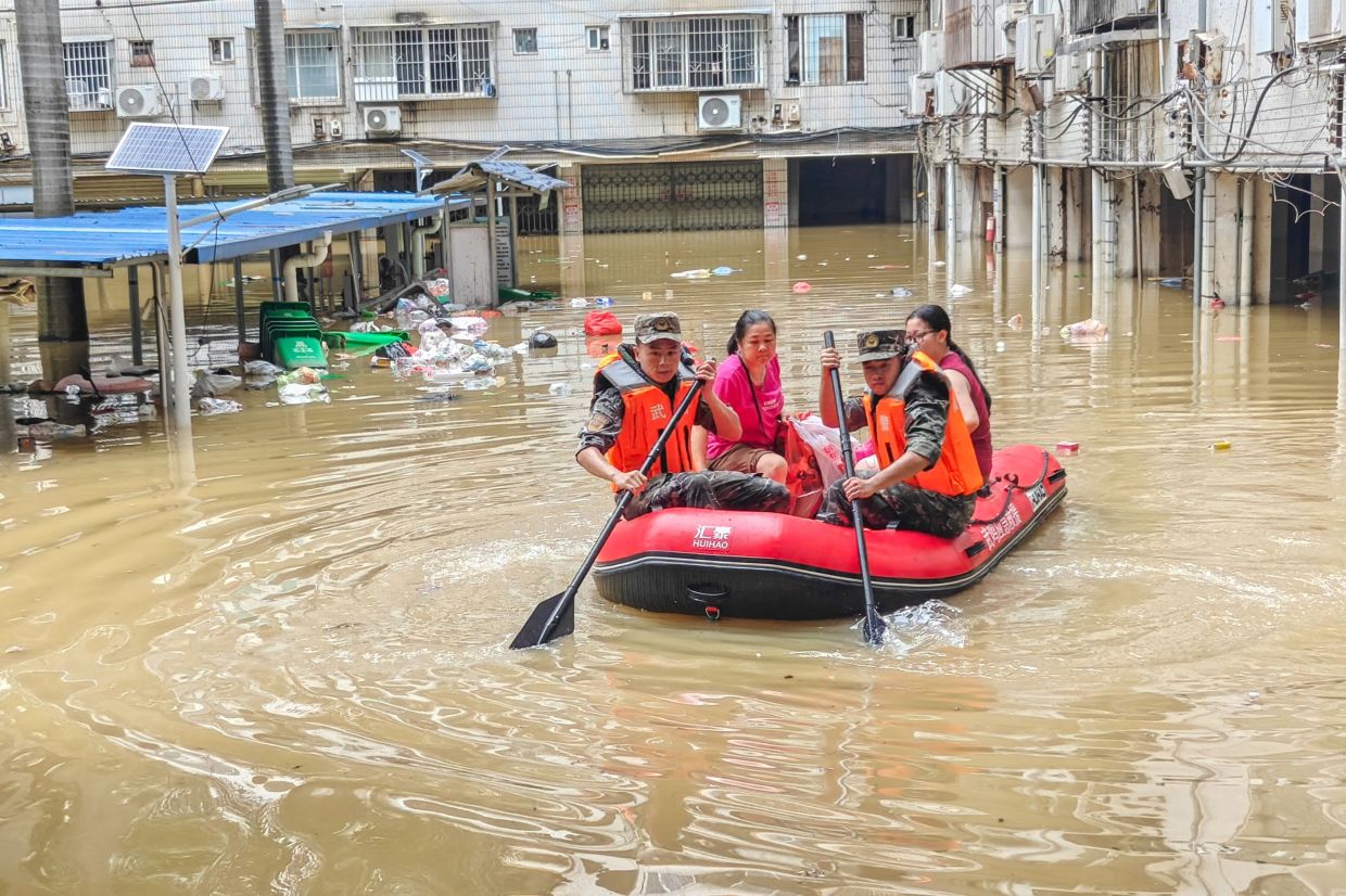 Paramilitary police evacuate flood-affected residents in Nanning, in China's southern Guangxi region. The death toll from devastating storms in parts of China rose to 15 on July 7, with hundreds more injured and tens of thousands evacuated, state media reported, as President Xi Jinping urged all-out rescue efforts. -- Photo by CNS / AFP