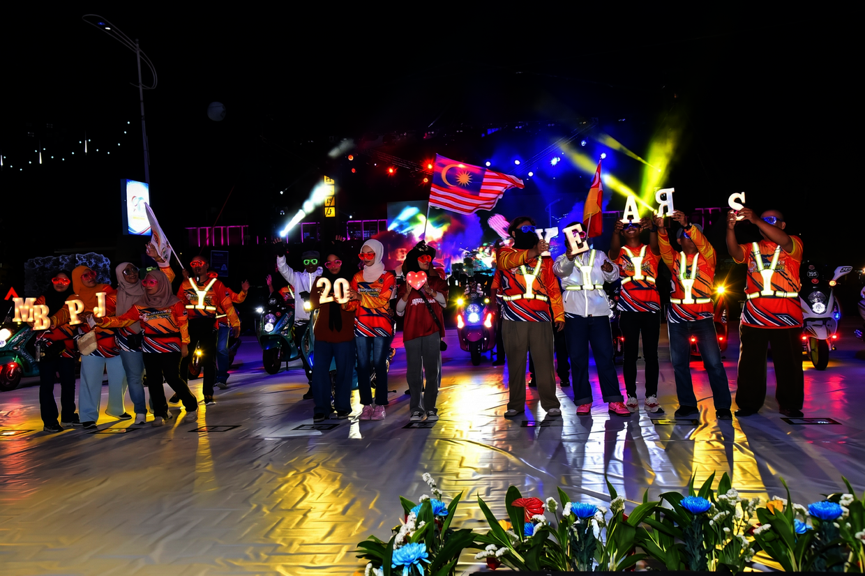 Performers dancing with illuminated props, creating a vibrant light display during their stage performance.