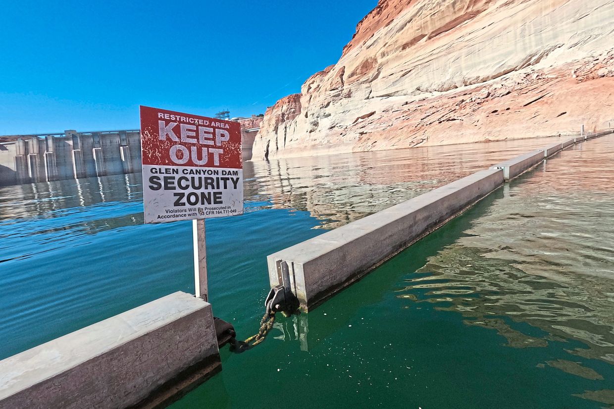A sign reading 'keep out' displayed just upstream of Glen Canyon Dam.