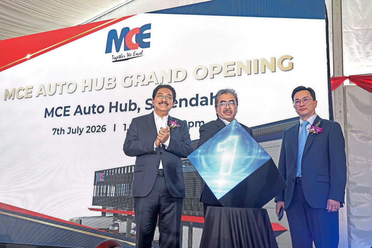 Johari (centre) at the launch of the new MCE Auto Hub in Serendah, flanked Abdul Rahman (left) and Goh. 