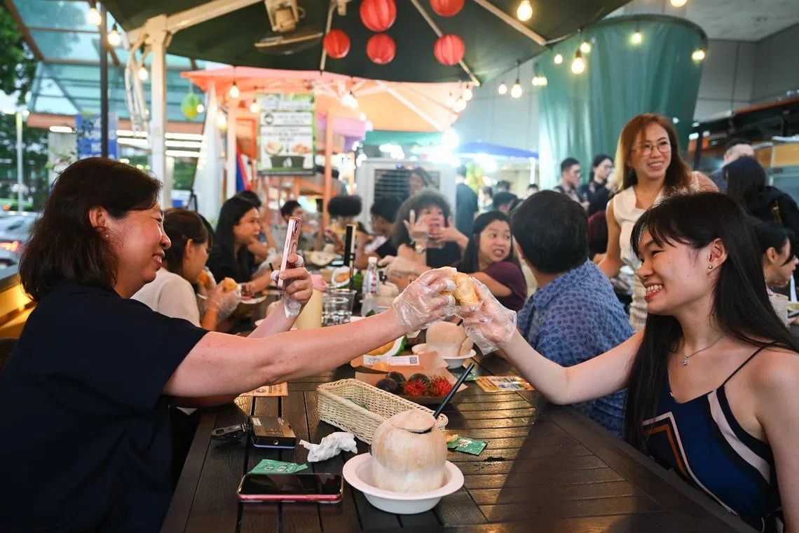 People enjoying durians at the launch of AGONG Durian at Thomson Plaza on July 9. - Photo: ST