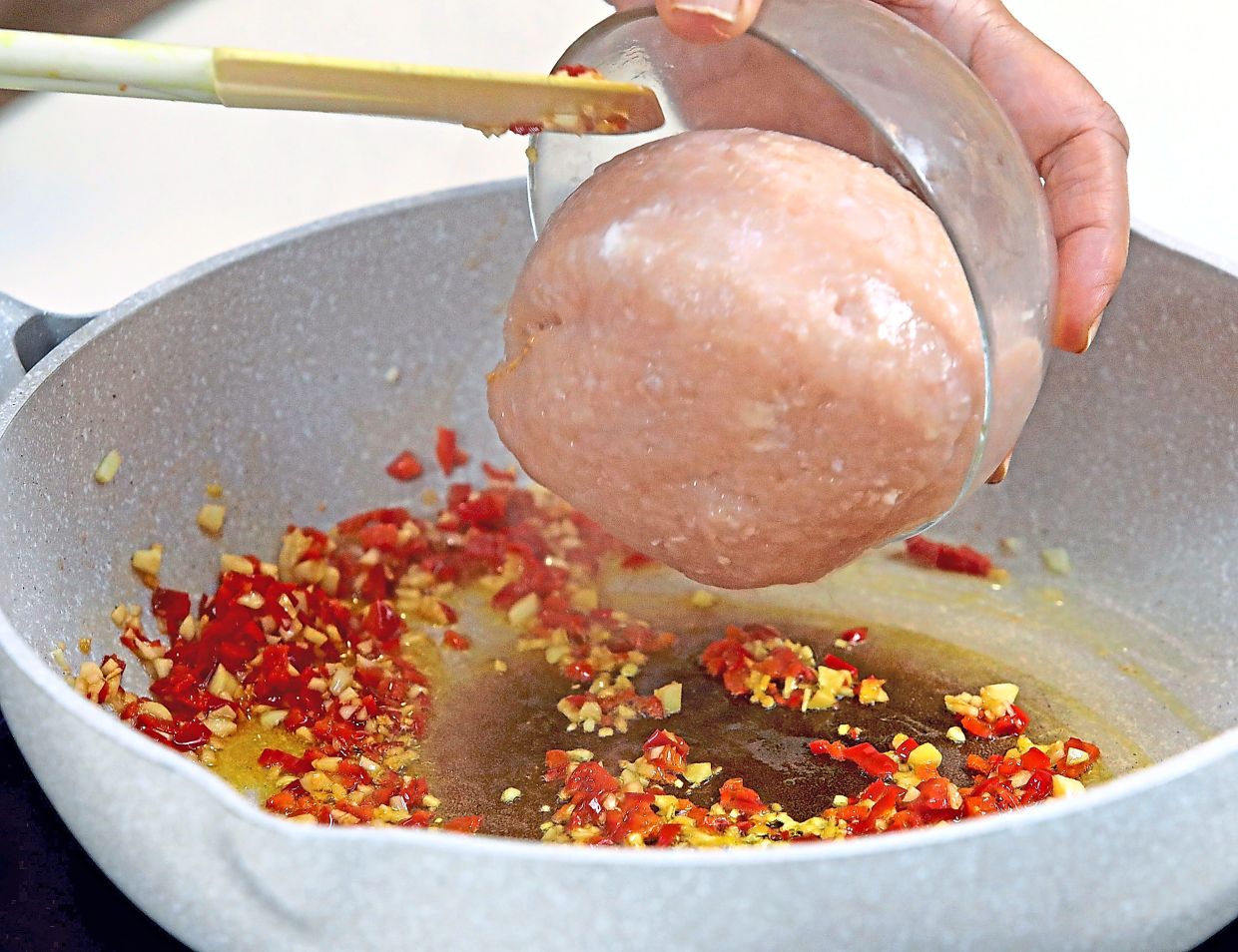 Once the garlic and red chillies have aromatised the oil, add the minced chicken.