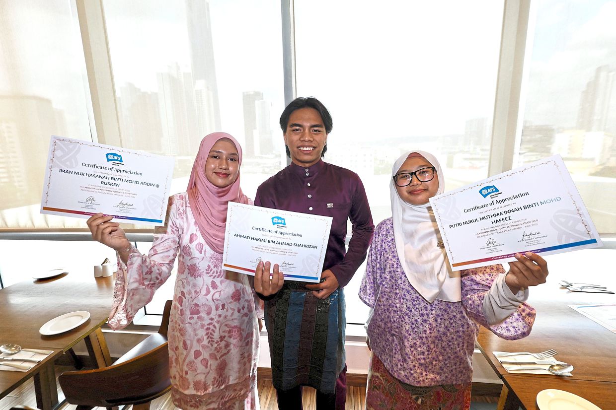 Beaming with pride: (From left) Iman Nur Hasanah, Ahmad Hakimi and Putri Nurul Muthma’innah posing with their certificates after the ceremony. — FAIHAN GHANI/The Star