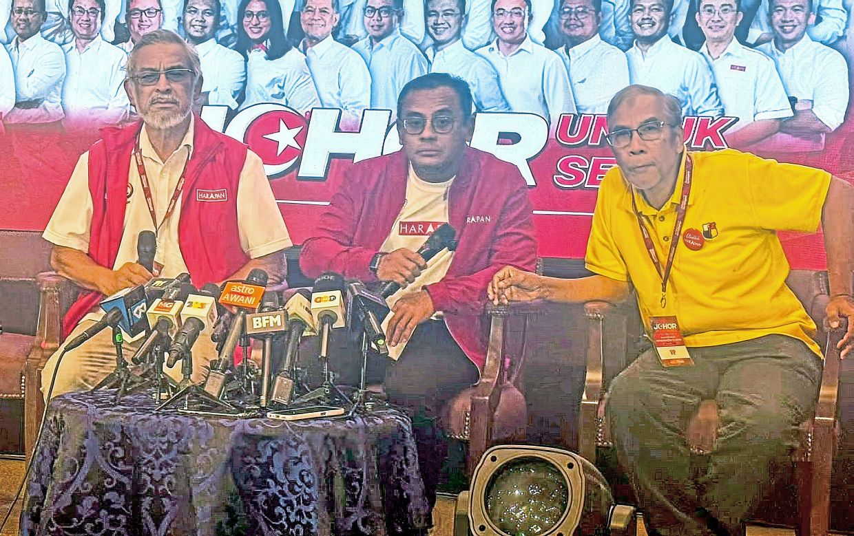 Sombre mood: Amirudin (centre) holding a press conference in Johor Baru following Pakatan’s disappointing performance in the state polls.