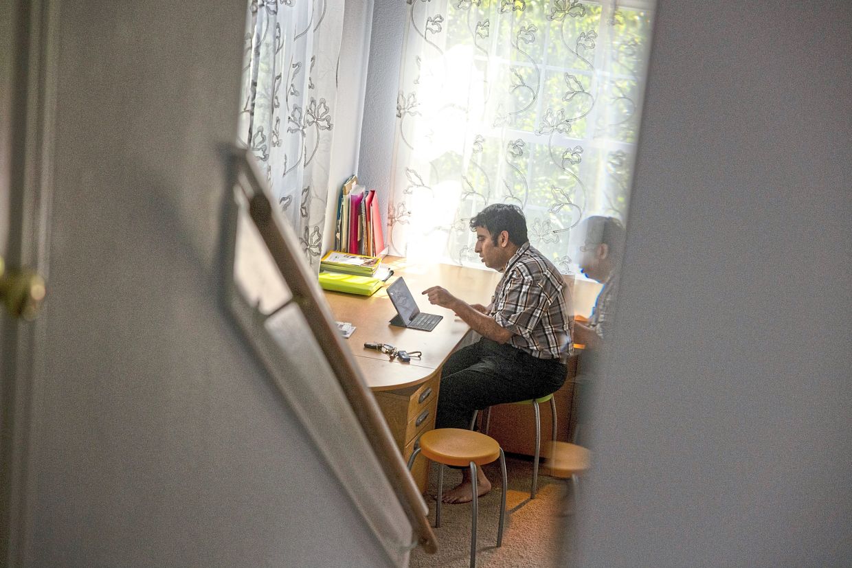 Tito demonstrates how he writes on a tablet at home in Austin, Texas.
