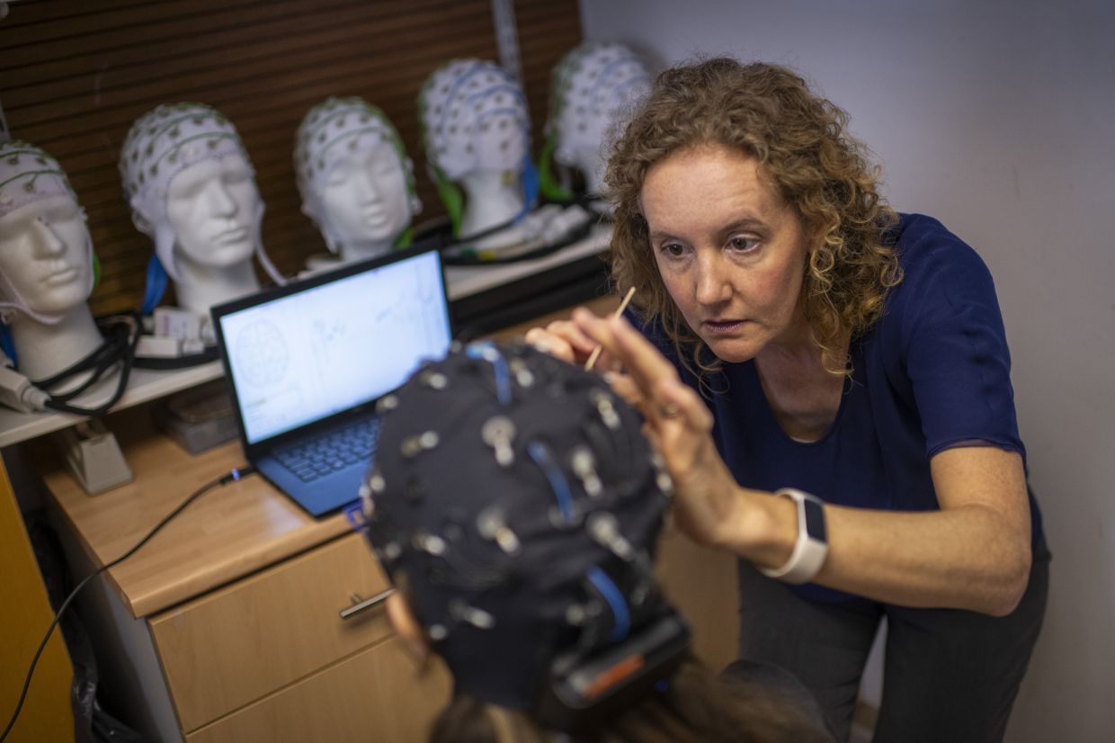 Dr. Alexandra Woolgar is using a technique that measures electrical activity in the brain to search for evidence of language comprehension, without requiring participants to produce any language of their own. — Photo: Joshua Bright/The New York Times